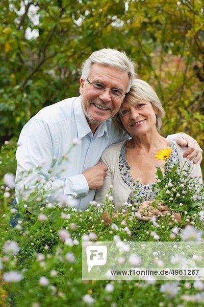 Deutschland  Kratzeburg  Seniorenpaar im Garten  lächelnd  Portrait