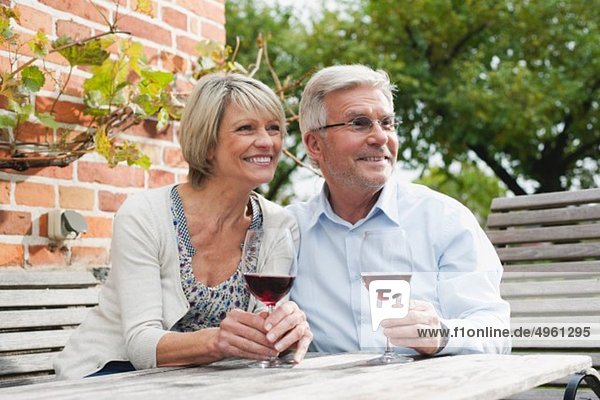 Deutschland  Kratzeburg  Seniorenpaar mit Weinglas in der Nähe von Landhaus