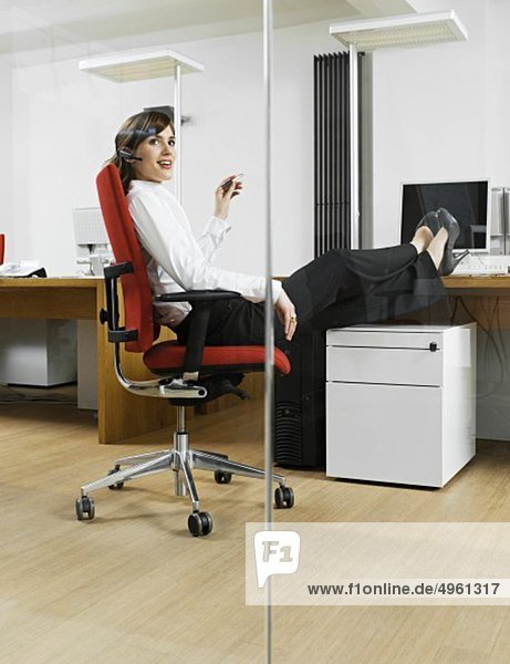 Junge Frau entspannt im Büro