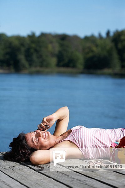 Eine Frau auf eine Mole an einem See  Schweden.