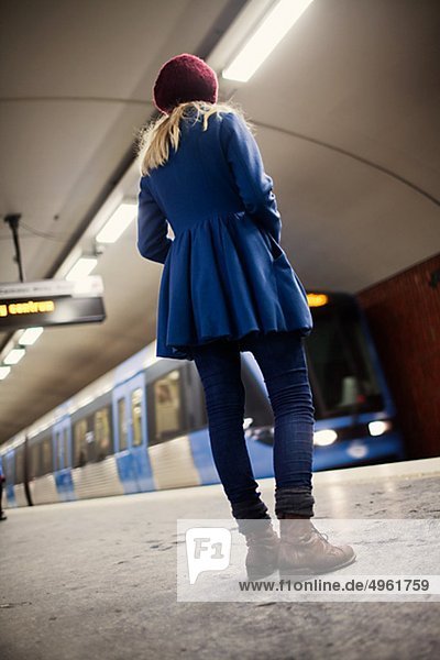 Teenage girl (14-15)standing on underground station platform