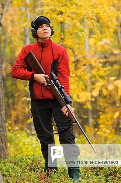 Hunter mit Gewehr im Wald