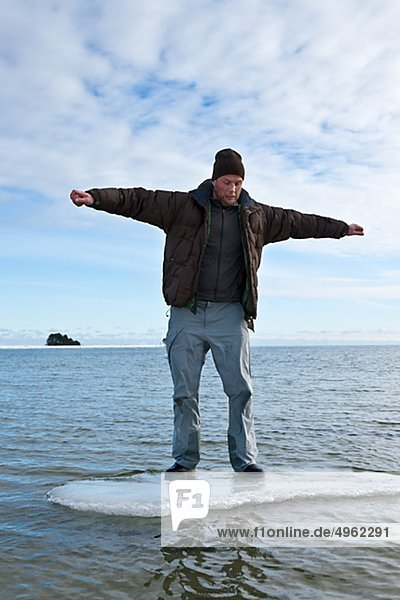 Junger Mann Standing on Ice Floe im Meer