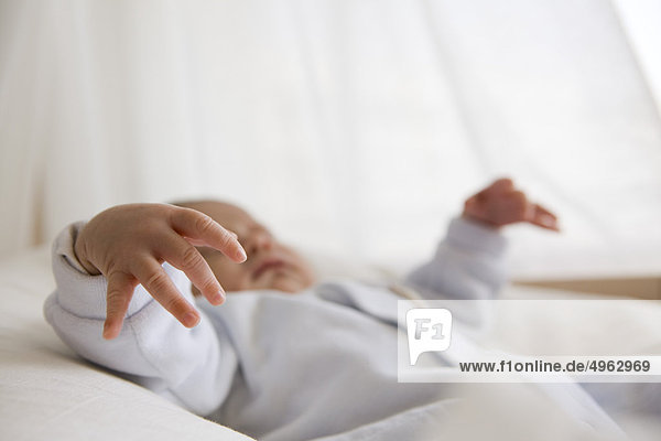 Baby schläft in der Krippe  Konzentration auf die Hand des Babys