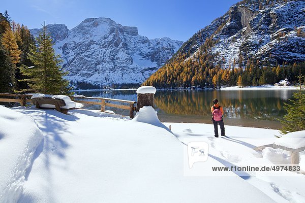 Frau steht am Pragser Wildsee im Winter Südtirol Italien