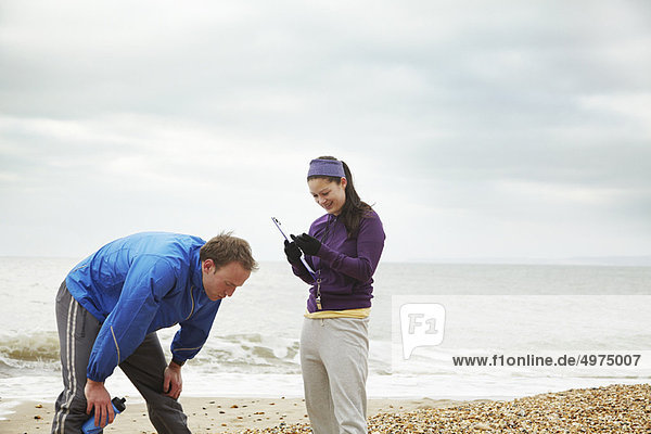 Fitness instructor with man on beach