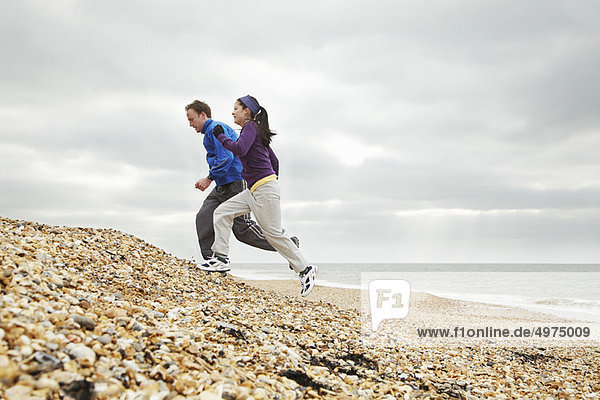 Couple exercising on stoney beach