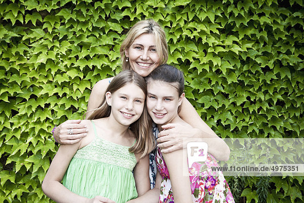 Mother and daughters in-front of bush