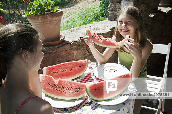Two girls eating watermelon