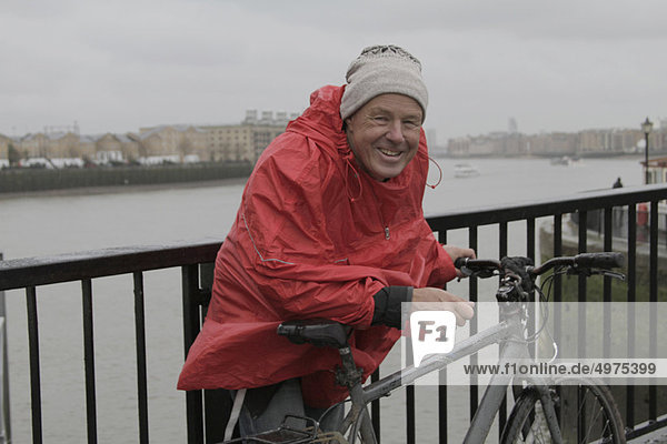 Man in raincoat with pushbike