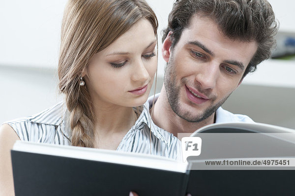 Junges Paar liest Buch zusammen