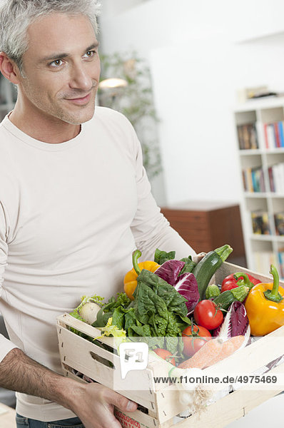 Healthy man with vegetables crate