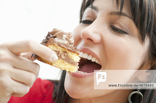 Lächelnde Frau isst Schokoladenkuchen