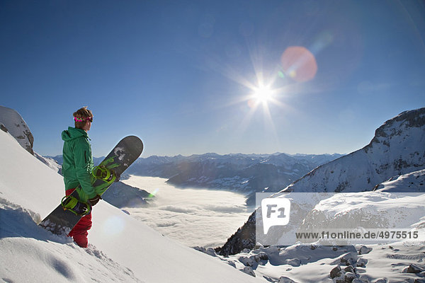 Snowboarder looking from mountain top