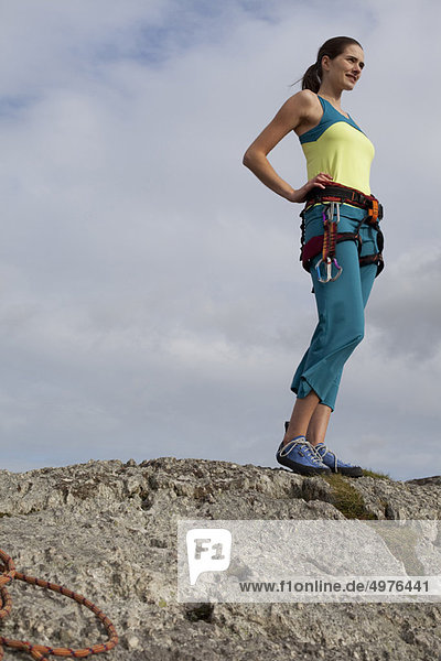 woman in climbing gear on top of rock