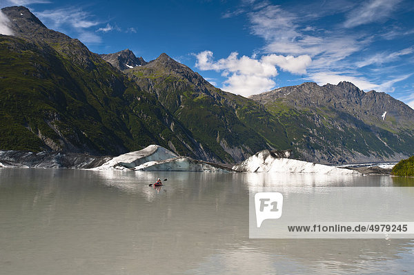 Man kayaking amongst icebergs in the lake at Valdez Glacier's terminus  Southcentral Alaska  Summer