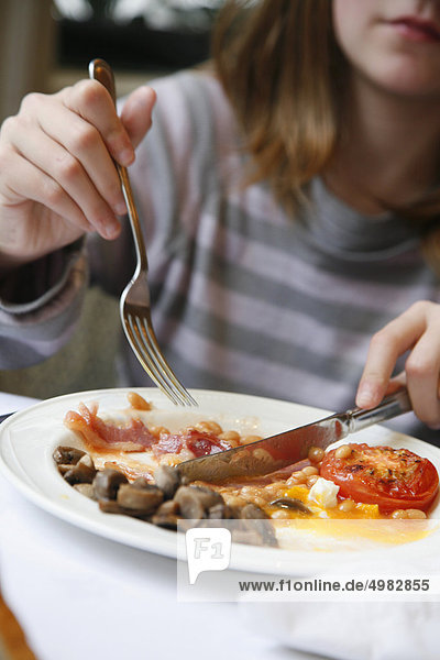 Teenager eating an english breakfast