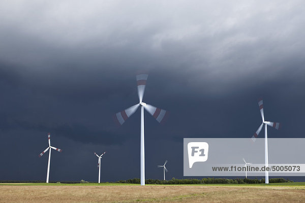 Windkraftanlagen  die sich auf einem Feld drehen