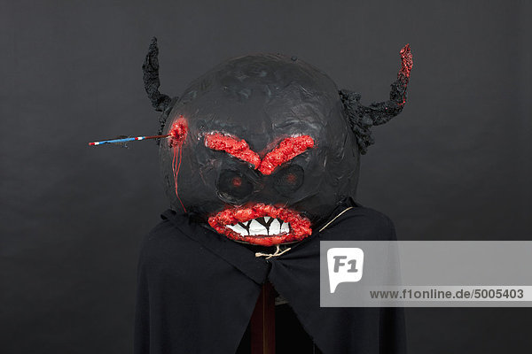 Dunkle Halloween Maske und schwarzer Umhang.