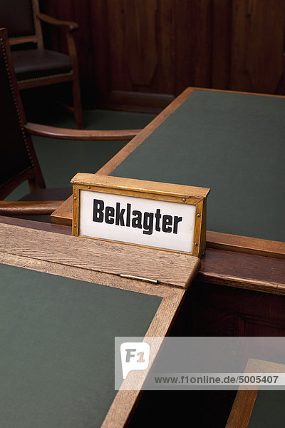 The German word  Beklagter  for defendant on a sign  among some tables and chairs.
