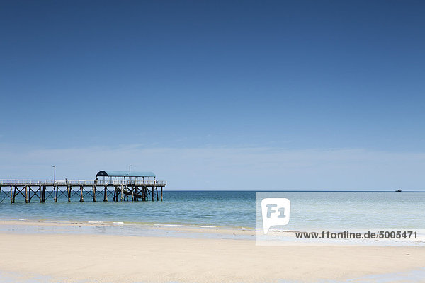 View of a pier from a sandy beach