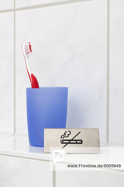 Ein Rauchverbot neben einer Zahnbürste im Becher