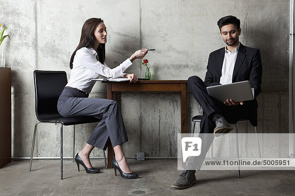 Ein Geschäftsmann und eine Geschäftsfrau in einem modernen Büro.