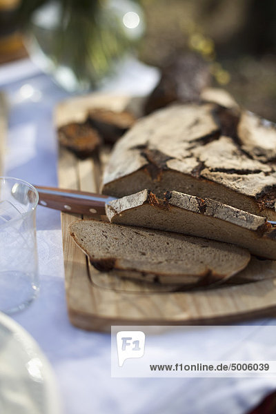 Roggenbrot teilweise auf einem Brotbrett außen geschnitten