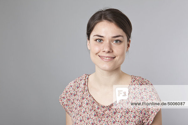 Eine fröhliche junge Frau lächelt in die Kamera  Porträt