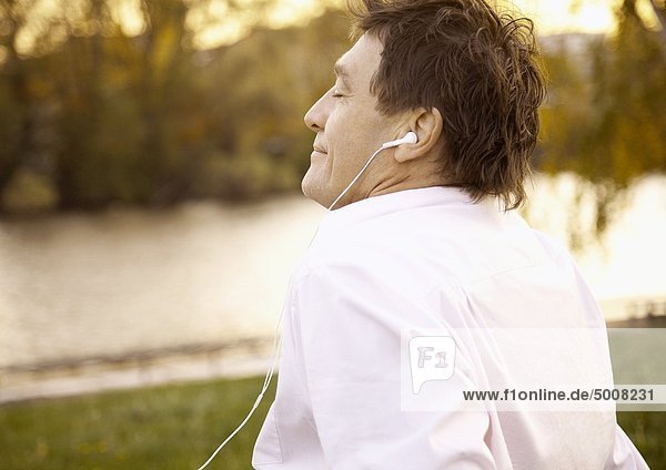 Entspannter Mann hört im Freien