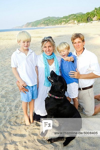 family on beach with dog