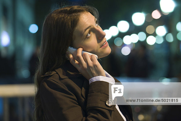 Woman talking on cell phone at night  looking upset