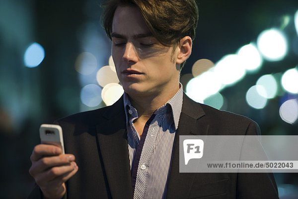 Mann Textnachrichten im Freien bei Nacht
