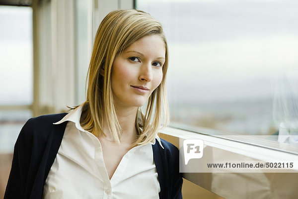 Woman leaning against window  portrait