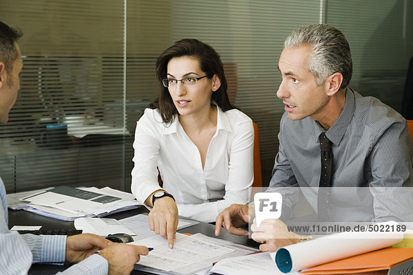 Clients discussing paperwork with businessman