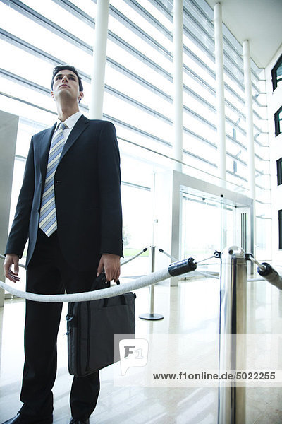 Businessman standing in lobby  looking up