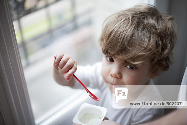 Kleinkind Junge isst Joghurt  Portrait
