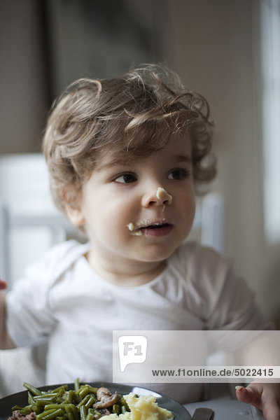 Toddler boy with food on his face  portrait
