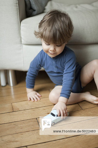 Toddler boy playing with toy car
