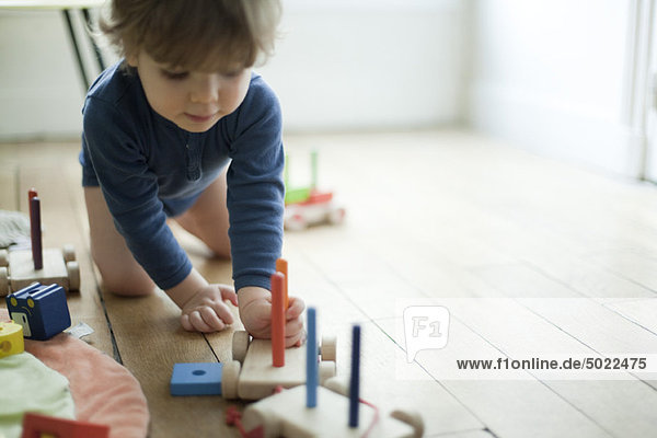 Kleinkind Junge spielt mit Spielzeugeisenbahn