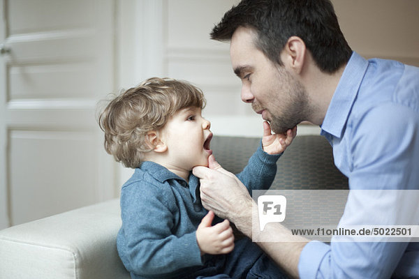 Vater untersucht die Zähne des kleinen Sohnes  Porträt