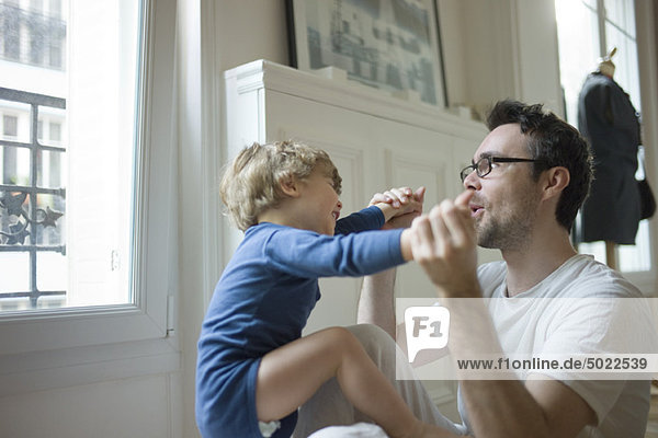 Father playing with toddler son
