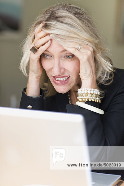 Frustrierte Geschäftsfrau mit Laptop