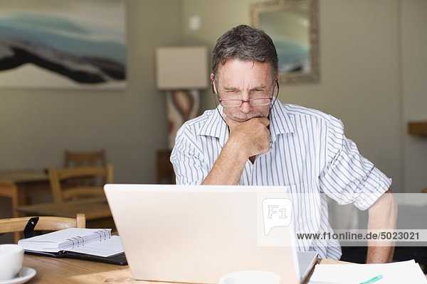 Serious businessman using laptop