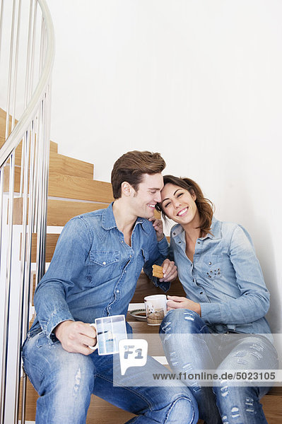 Couple drinking coffee on stairs