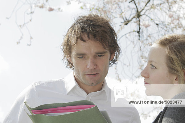 Couple holding folder outdoors