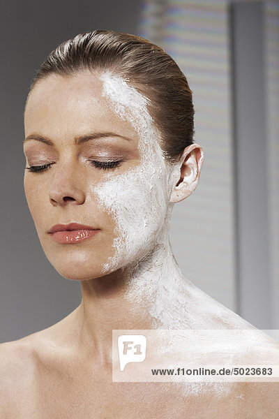 Frau mit Feuchtigkeitscreme auf Gesicht und Hals