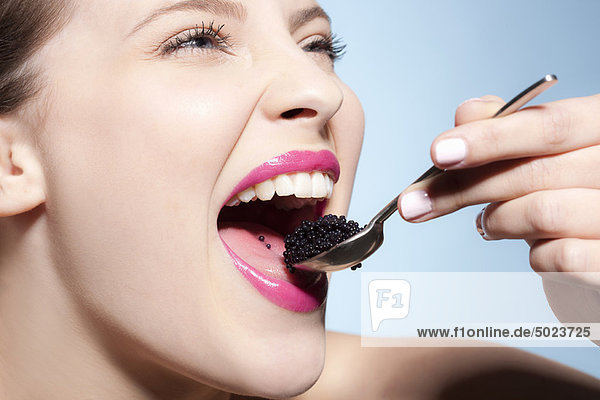 Smiling woman eating caviar