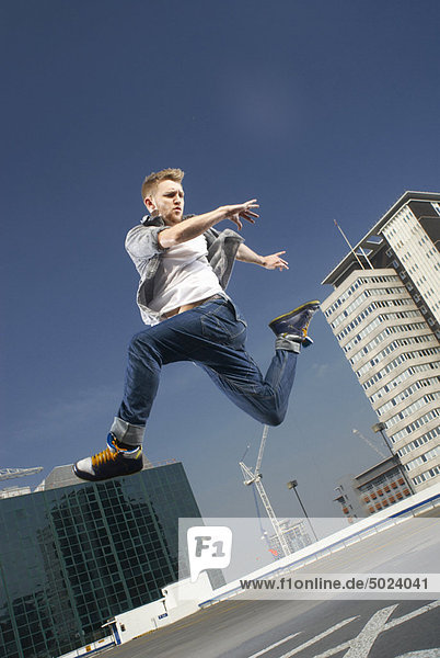 Man jumping on urban rooftop