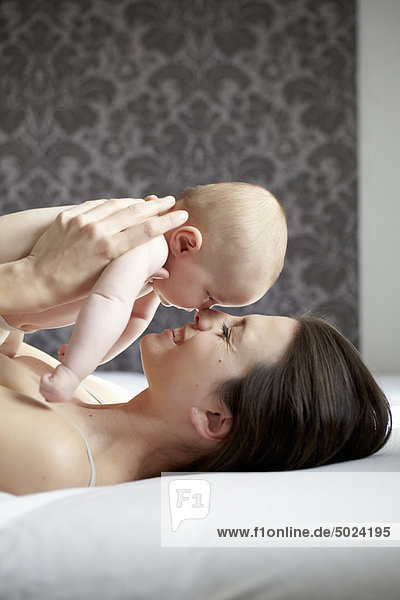 Frau wiegt nacktes Baby